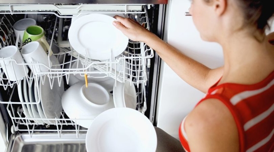 woman using dishwasher