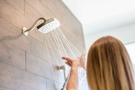 woman catching water from the shower