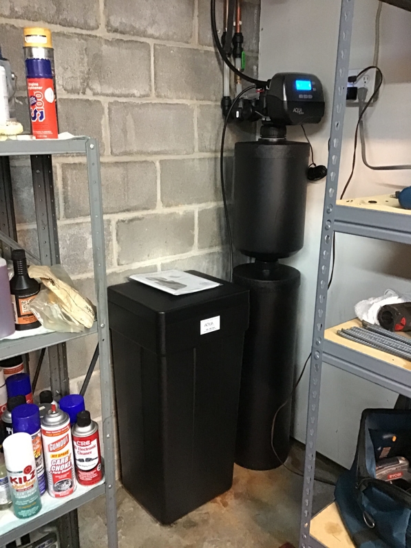 A black water conditioner installed in a garage